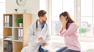 Чоловік тримається за скроню через сильний головний біль як типову ознаку мігрені